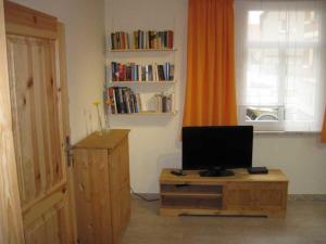 Habitación con TV en una mesa de madera y una ventana. en Gästehaus Gimper en Bad Klosterlausnitz