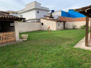 a child standing in the yard of a house at Recanto do Peixe Dourado kitnet in Casimiro de Abreu