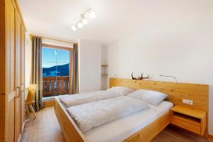 a bedroom with a large bed and a window at Unterdurachhof Apartment Valentina in Ultimo