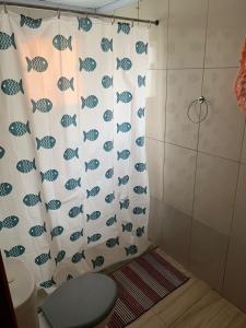 uma cortina de chuveiro na casa de banho com WC em Recanto do Peixe Dourado kitnet em Casimiro de Abreu