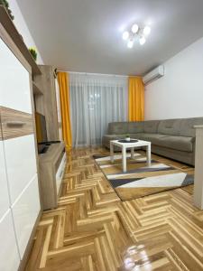 a living room with a couch and a table at Apartman Lux 5- private parking in Sombor