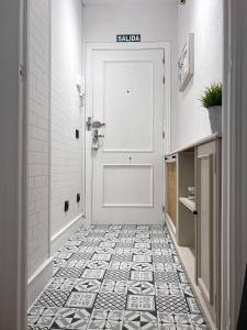 baño con puerta blanca y suelo de baldosa en Casa Yolanda, en Ávila