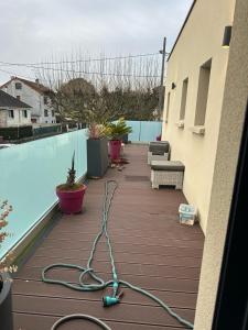 ein Schlauch auf einer Terrasse neben einem Pool in der Unterkunft non disponible in Champigny-sur-Marne