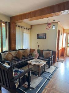 a living room with a couch and a table at Nest Villa Homestay in Nagar