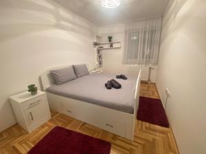 a bedroom with a bed with a stuffed animal on it at Apartman Lux 5- private parking in Sombor