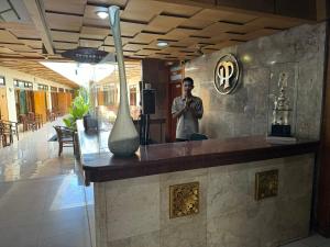 a man standing behind a bar in a restaurant at Hotel Priangan in Cirebon