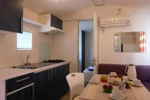 a small kitchen with a table with fruit on it at Happy Camp mobilehomes in Camping Apollonia in Plakias