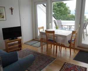 - un salon avec une table, des chaises et une télévision dans l'établissement Haus Wörle, à Nonnenhorn