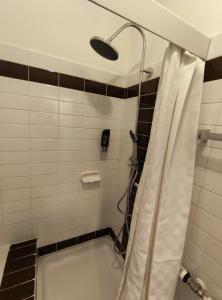 baño con ducha con cortina blanca en Gästehaus am Bahnhof, Self Check In en Vechta