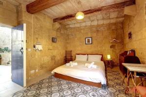 a bedroom with a bed in a stone wall at Historic Hideaways - 900 Year Old Converted Studios in Victoria