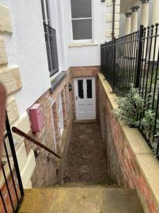 a small alley with a white door in a building at 1 Hatton house 2 bedroom 2 bathroom spacious basement flat in Newark upon Trent