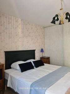 um quarto com uma grande cama branca e 2 almofadas em Le Repère appartement centre-ville em Les Herbiers