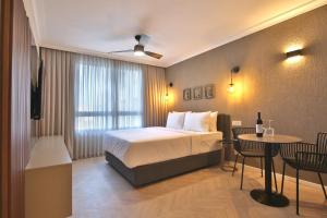 a hotel room with a bed and a table and chairs at Luxury Suites by Notaly Ariel - Carmel Beach in Haifa