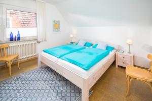 een slaapkamer met een groot bed en een raam bij Himmelsrichtung in Norderney