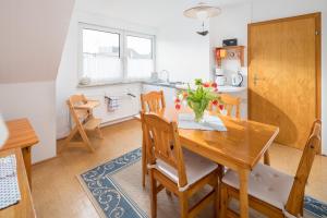 een keuken en eetkamer met een houten tafel en stoelen bij Himmelsrichtung in Norderney