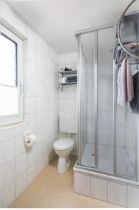 een badkamer met een toilet en een douche bij Himmelsrichtung in Norderney