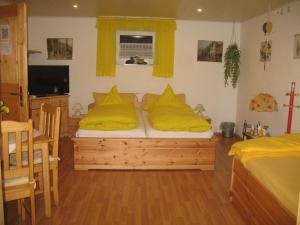 a bedroom with a bed with yellow pillows on it at Haus Edith Kempa in Sankt Aldegund