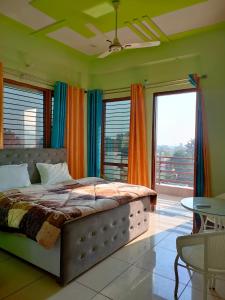 sypialnia z łóżkiem w pokoju z oknami w obiekcie Laxmi Jawahar Homestay w mieście Dehradun