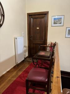 Zimmer mit einem Tisch, einem Stuhl und einer Tür in der Unterkunft Nikolas Guesthouse in Koukkoúlion