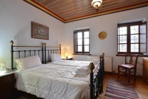 a bedroom with a large bed with a wooden ceiling at Nikolas Guesthouse in Koukouli