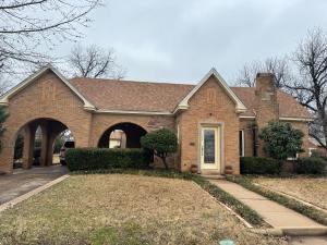 a brick house with an archway and a driveway at V's Iris Haven in Abilene