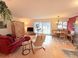 uma sala de estar com um sofá vermelho e uma sala de jantar em Ferienwohnung Bergnest em Bad Hindelang