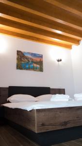 een bed in een kamer met een houten plafond bij Villa Wild Rooms in Jieţ