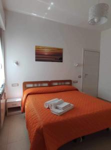 een slaapkamer met een oranje bed met 2 handdoeken erop bij CASA VACANZE CASANOVA in Agerola