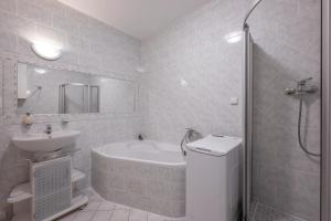 a bathroom with a tub and a sink and a toilet at Apartmán Karin in Jihlava
