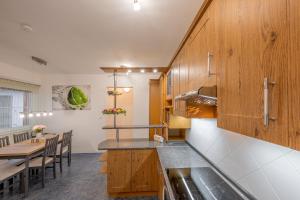 a kitchen with wooden cabinets and a dining table at Apartmán Karin in Jihlava