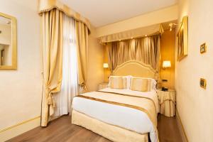 um quarto com uma cama grande e uma janela em Hotel A La Commedia em Veneza