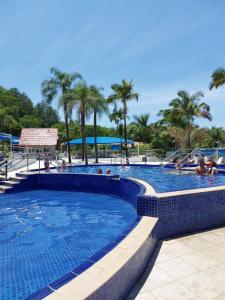 ein Schwimmbad in einem Resort mit Menschen darin in der Unterkunft Apto das Lavandas - à 150m do Parque Termal! in Piratuba
