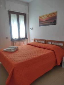 a bedroom with a orange bed with two windows at CASA VACANZE CASANOVA in Agerola