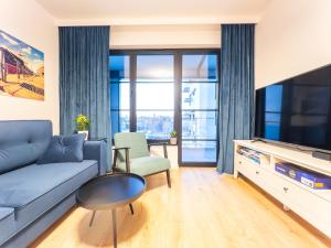 Televízia a/alebo spoločenská miestnosť v ubytovaní Apartament z dwiema sypialniami + parking