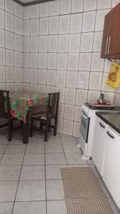 uma cozinha com uma mesa, uma mesa e um fogão em Kit no Centrinho da Lagoa em Florianópolis