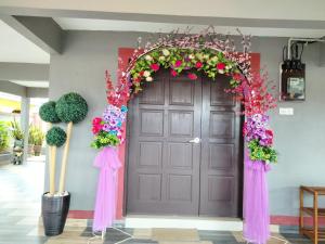 a purple door with areath of flowers on it at Weng Kong Homestay in Slim River