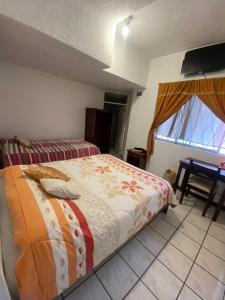 a bedroom with a bed and a table and a window at Hostal Almagro in Quito