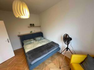 ein Schlafzimmer mit einem Bett, einem Ventilator und einer Lampe in der Unterkunft Studio Angelina im 3 OG 30 m² in Graz