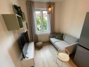 ein kleines Wohnzimmer mit einem Sofa und einem TV in der Unterkunft Studio Angelina im 3 OG 30 m² in Graz