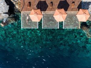 an overhead view of a pool of water with umbrellas at Aquila Elounda Village Resort, Suites & Spa in Elounda