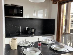 a kitchen counter with plates and wine glasses on it at Appartement Les Gets, 1 pièce, 4 personnes - FR-1-671-63 in Les Gets