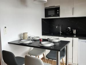 una mesa negra con sillas y vasos en la cocina en Appartement Les Gets, 1 pièce, 4 personnes - FR-1-671-63, en Les Gets