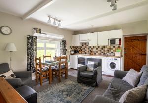 a living room with a table and chairs and a kitchen at Hobsons Cottage in Grinton