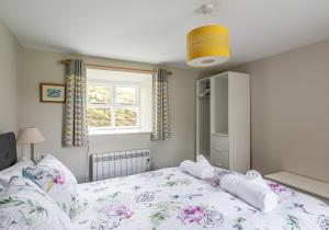 a bedroom with a bed and a window at Hobsons Cottage in Grinton