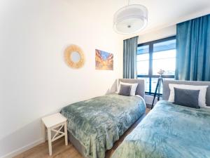 um quarto com 2 camas e uma janela em Apartament z dwiema sypialniami + parking em Gdansk