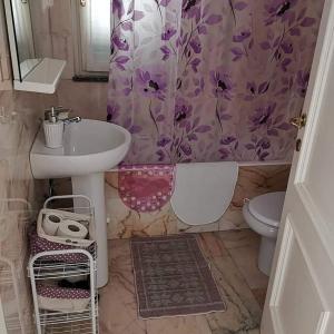 a bathroom with a sink and a purple shower curtain at La Casina di sopra AAUT in Sestri Levante
