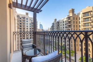 a balcony with two chairs and a table and some buildings at SuperHost - Urban Elegance 2BR in Asayel 2 Near Burj Al Arab in Dubai