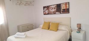 - une chambre avec un lit blanc et des oreillers jaunes dans l'établissement La Cantora, à Sagonte