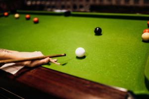 a cue ball and a cue stick on a pool table at Sherwood Castle by Liv Retreats in Nottingham