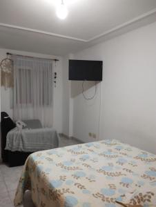 um quarto com uma cama e uma televisão na parede em Departamento ArturoV em Río Cuarto
